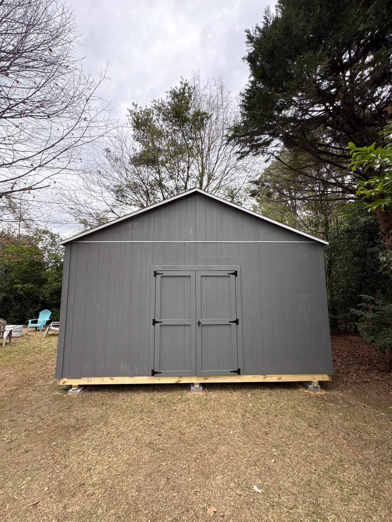 Charcoal shed with matching charcoal double doors, black hardware and white trim along the roof line